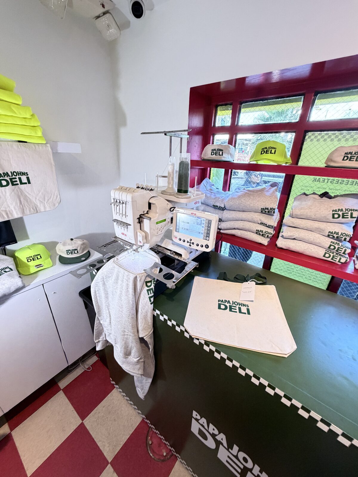 Custom merch displayed in a modern shop interior with checkered floors