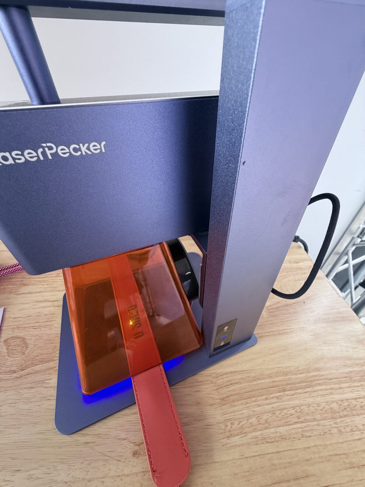 Laser engraver mid-burn customizing goods at a live event station