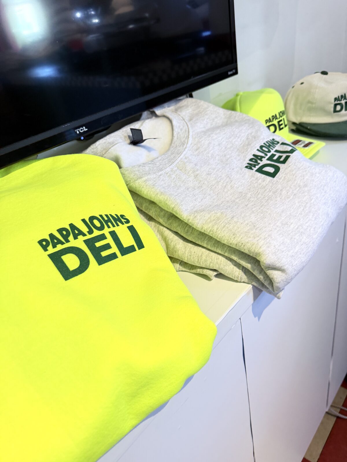 Freshly printed fluorescent merch folded at a Los Angeles pop-up