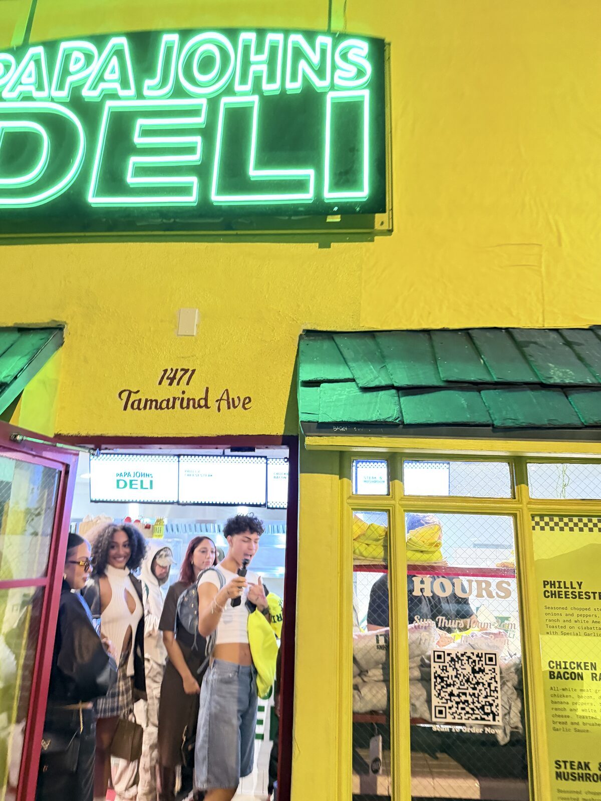 Guests outside a neon-lit streetwear pop-up during a Los Angeles brand activation